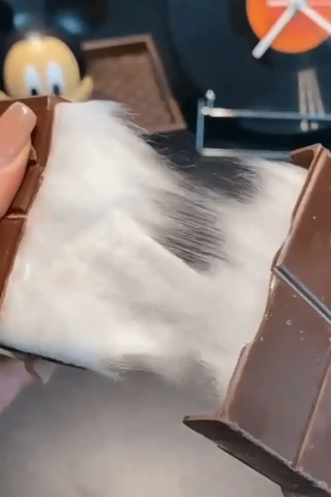 Cotton candy being pulled from chocolate bar
