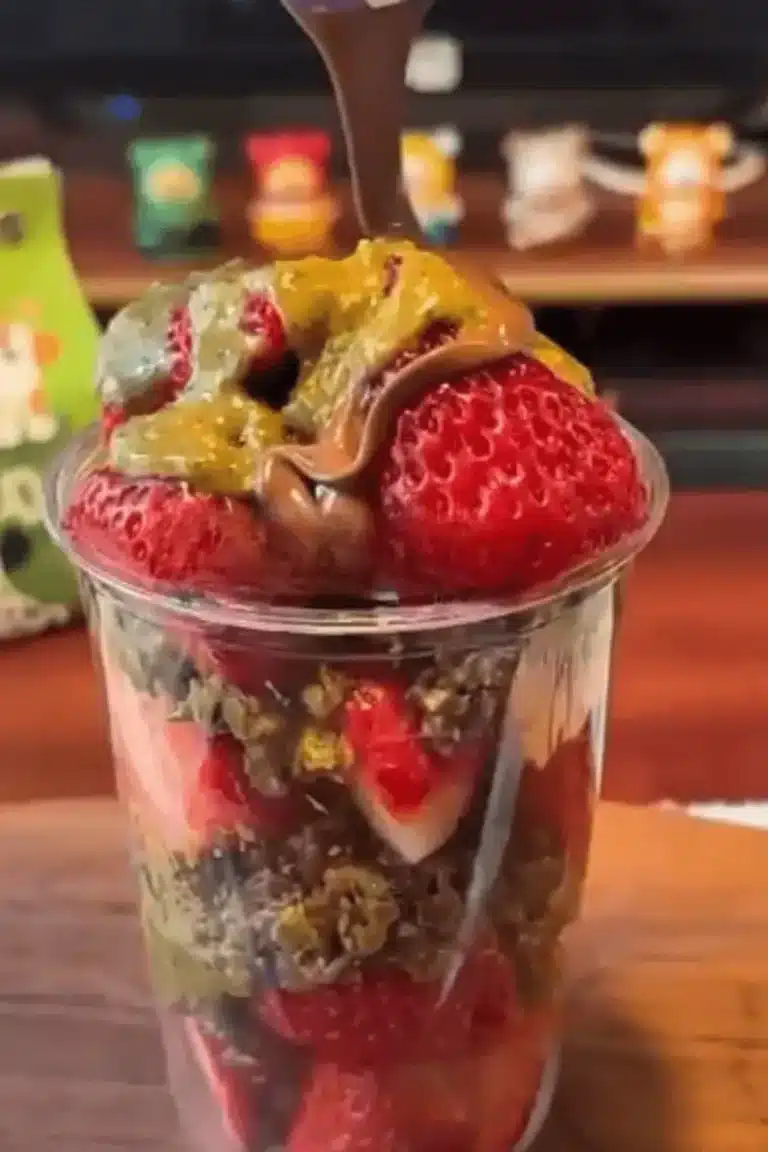 Drizzling melted chocolate on top of Dubai strawberry cup