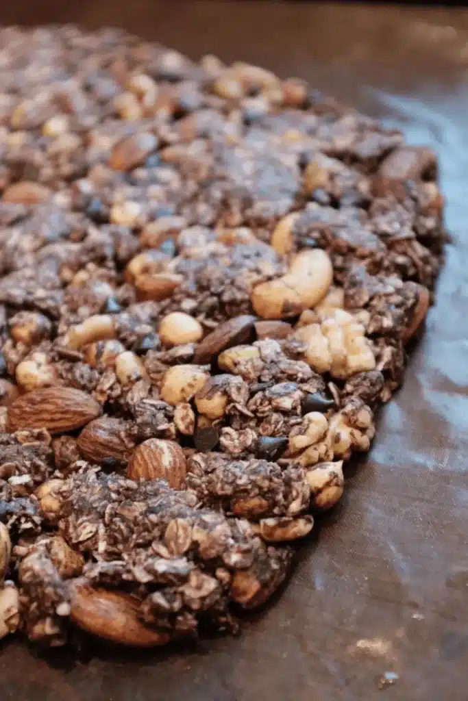 Chocolate protein baked oats slab with mixed nuts cooling on a tray