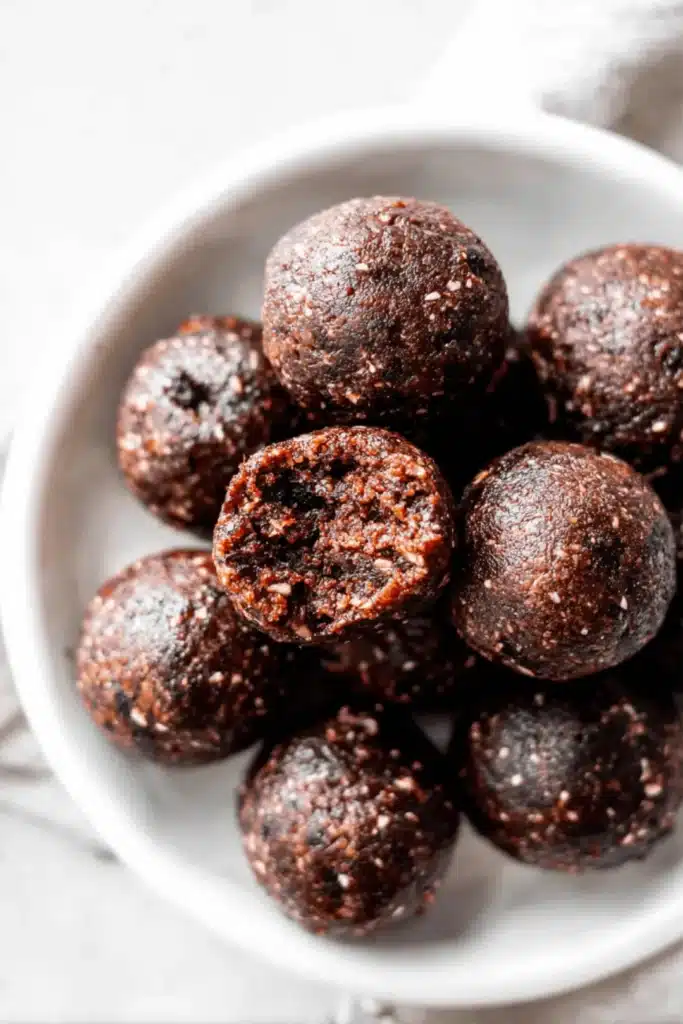 Close-up of date brownie balls on a white plate – no-bake, 3-ingredient healthy snack