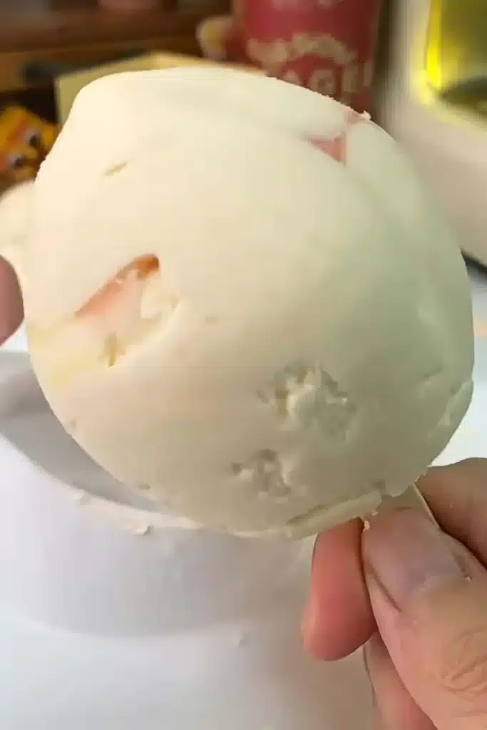 No-churn peach ice cream bar with real fruit before white chocolate coating