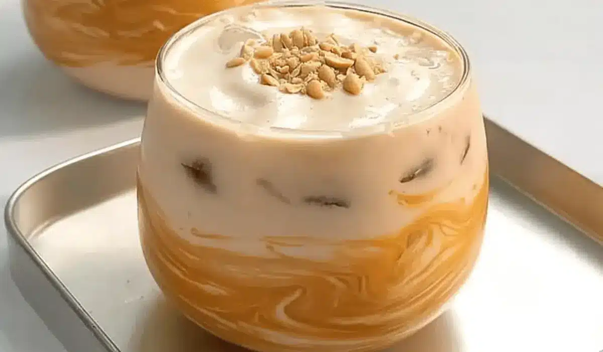 Creamy peanut butter iced latte swirled with milk and topped with crushed peanuts
