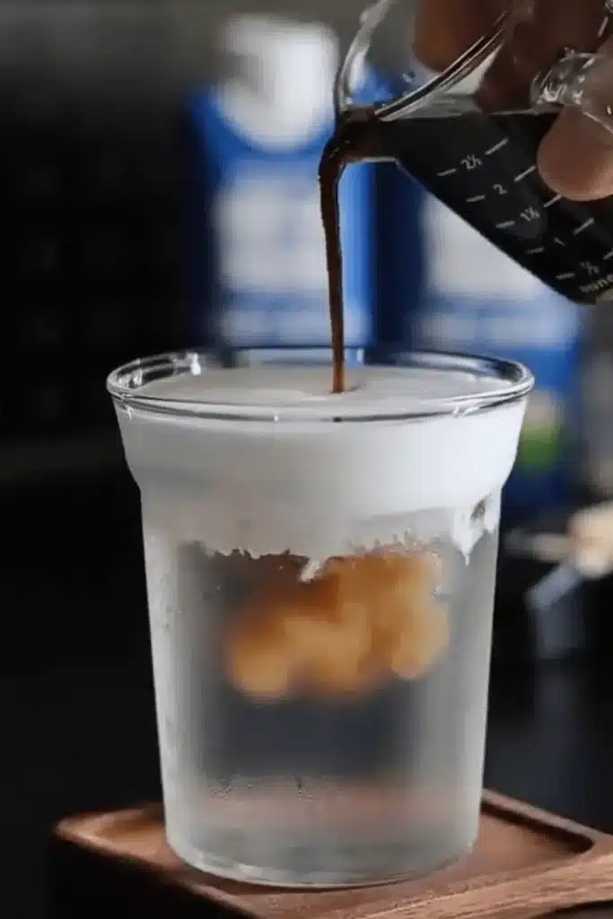 Espresso poured into Coconut Cloud Coffee with fluffy cream and chilled coconut water base