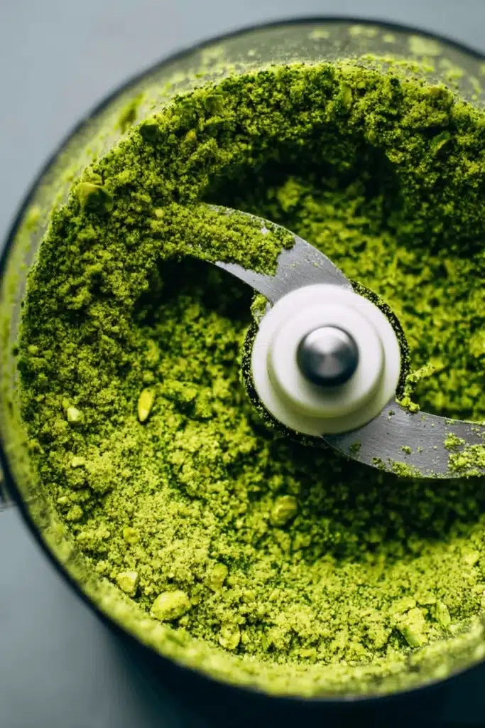 Crushed pistachios inside a food processor for pistachio cream recipe