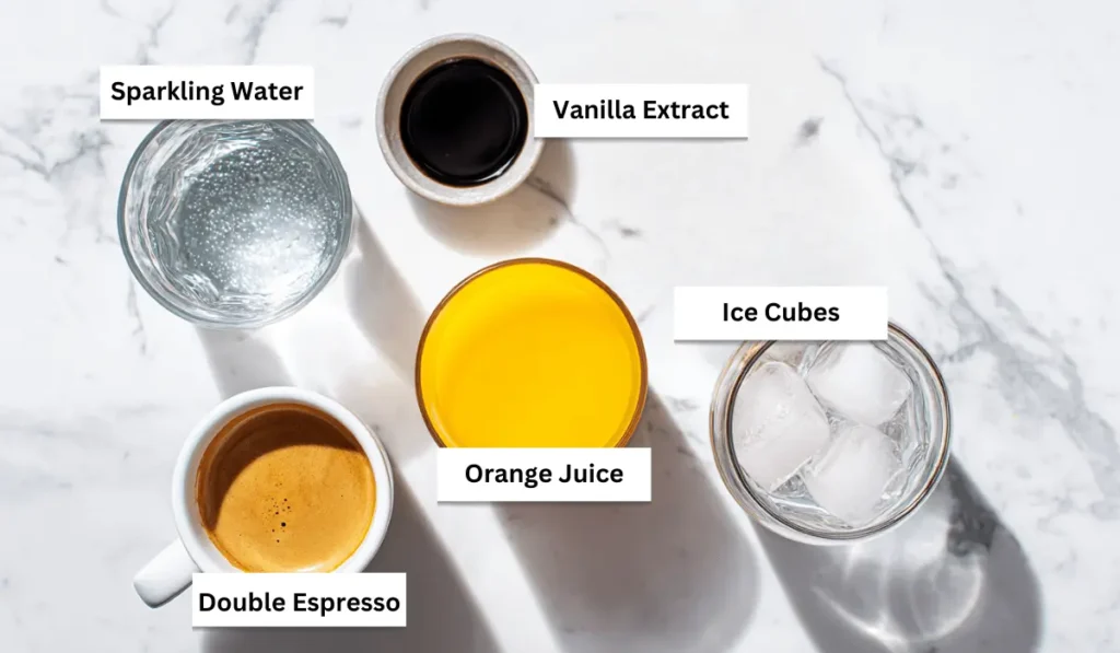 Ingredients for orange coffee recipe including orange juice, espresso, vanilla extract, ice, and sparkling water