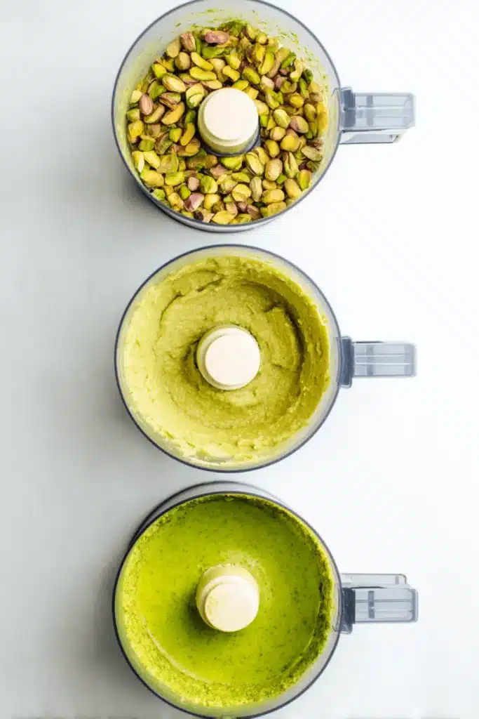 Three stages of how to make pistachio butter in a food processor, from whole nuts to smooth green butter.