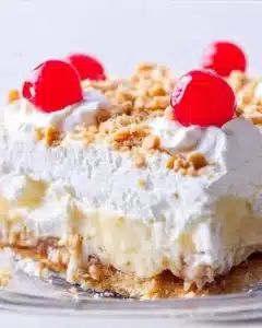 Deliciously layered Banana Split Cake with banana slices, whipped cream, and chocolate syrup