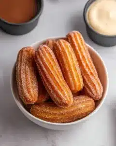 Plate of delicious baked churro bites dusted with cinnamon sugar.