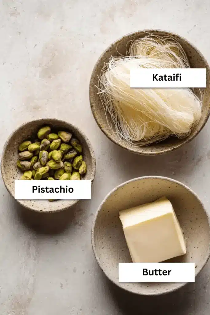Ingredients for the Dubai chocolate filling recipe laid out on a counter: a bowl of raw kataifi pastry, a bowl of pistachios, and a block of butter.