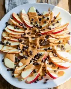 Healthy apple nachos topped with peanut butter and chocolate chips for a nutritious snack.