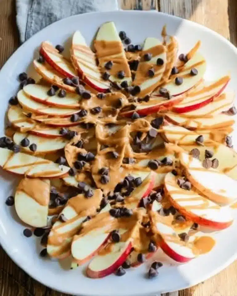 Healthy apple nachos topped with peanut butter and chocolate chips for a nutritious snack.